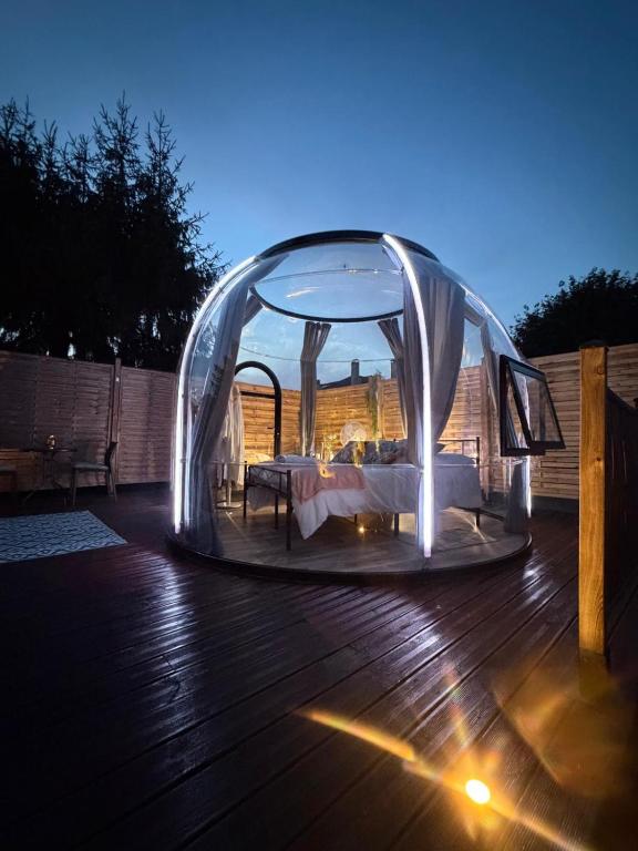 a canopy bed on a deck at night at Reves2bulles in Ousse
