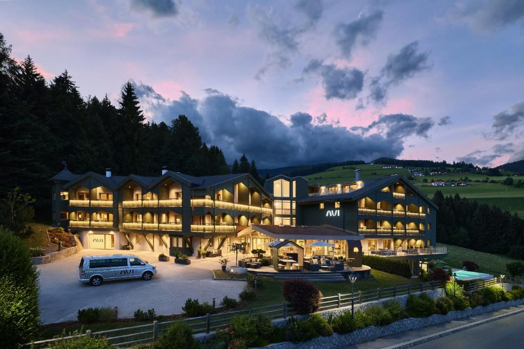 a large mansion with a van parked in a parking lot at Hotel AUI in Maranza