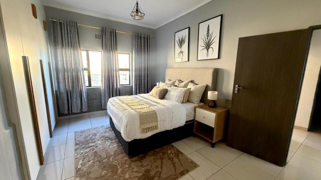 a bedroom with a bed with white sheets and pillows at Siwela in Darkton