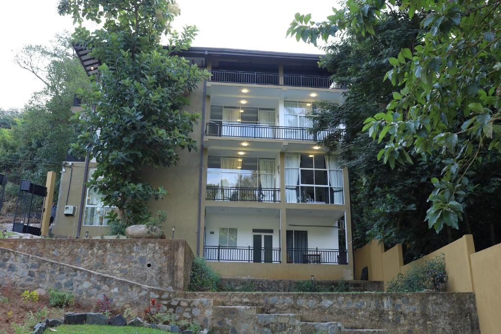 an apartment building with balconies and trees at Ayurya Wellness Retreat in Kandy