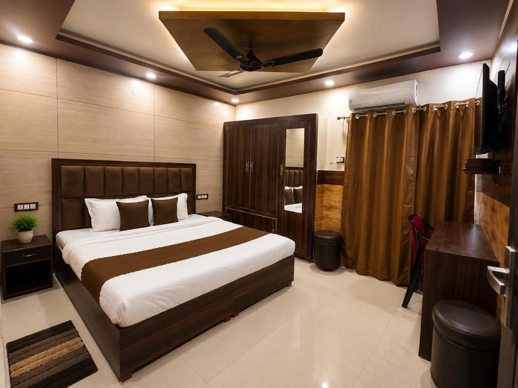 a bedroom with a large bed and a ceiling at Hotel Famous in Haridwār