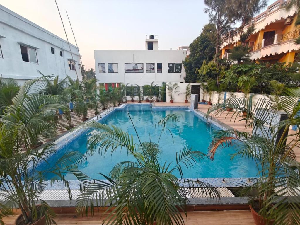 a large blue swimming pool next to a building at JBL Beach Resort Mandarmoni in Mandarmoni