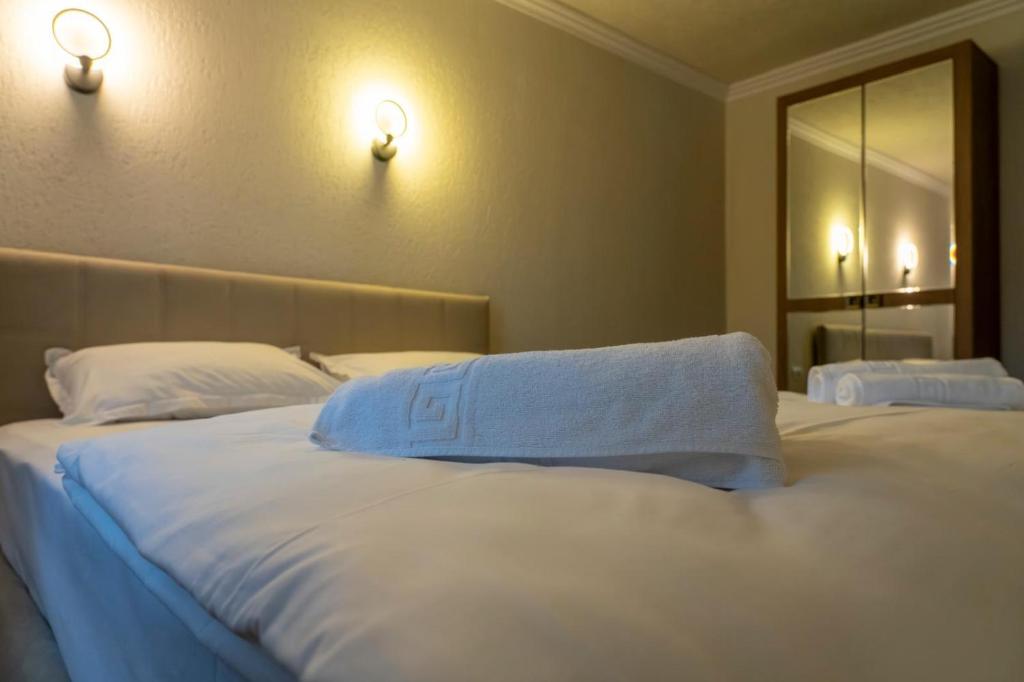 a bedroom with a large white bed with a mirror at Vila dintre Brazi in Râu de Mori