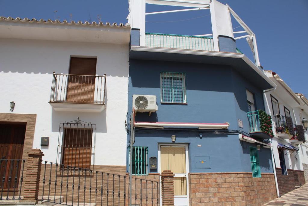 a blue and white house with a balcony at Casa Nido in Ríogordo
