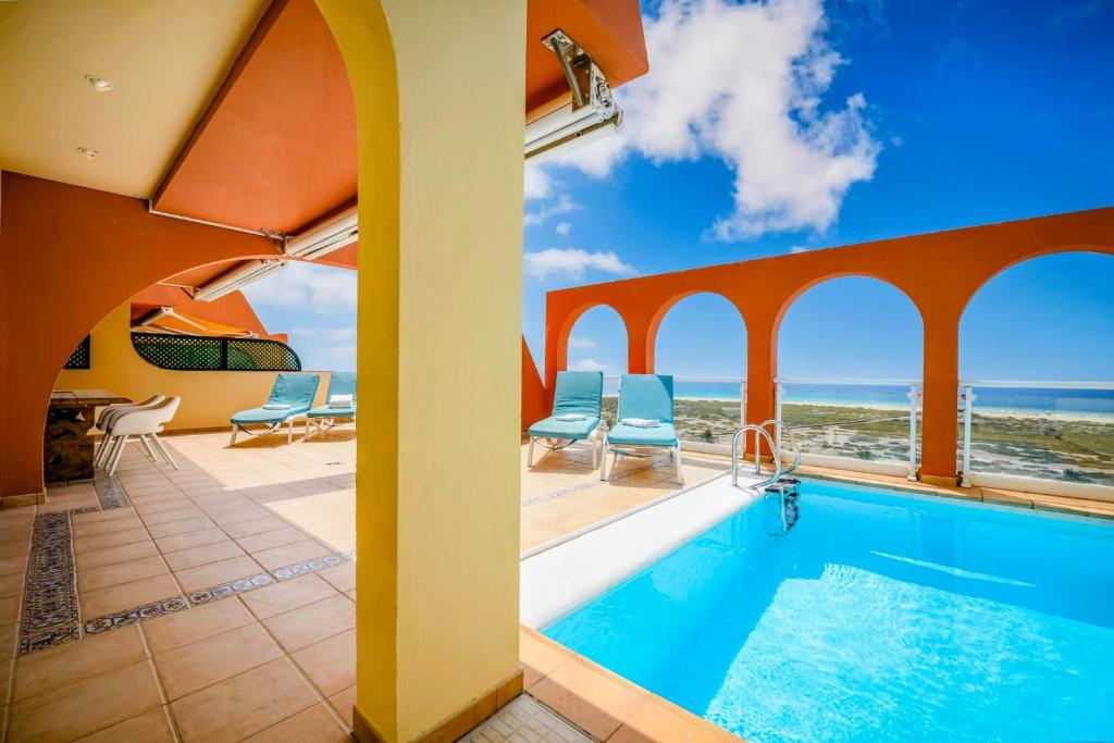 a villa with a swimming pool and the ocean at Villa Afreen Playa in Morro del Jable