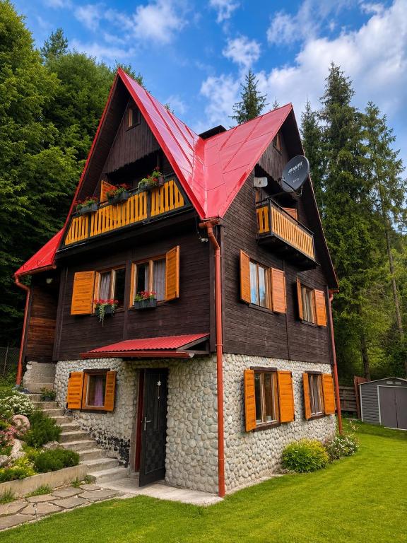 a wooden house with a red roof at Chata Juliana in Malý Lipník