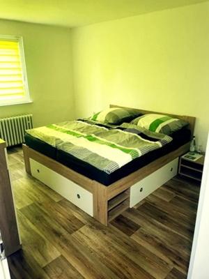 a bedroom with a bed with green sheets on it at Pension am Schottenring in Schotten