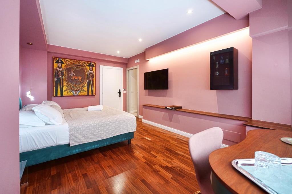 a bedroom with a bed and a table and a tv at Tao chambre in Taormina