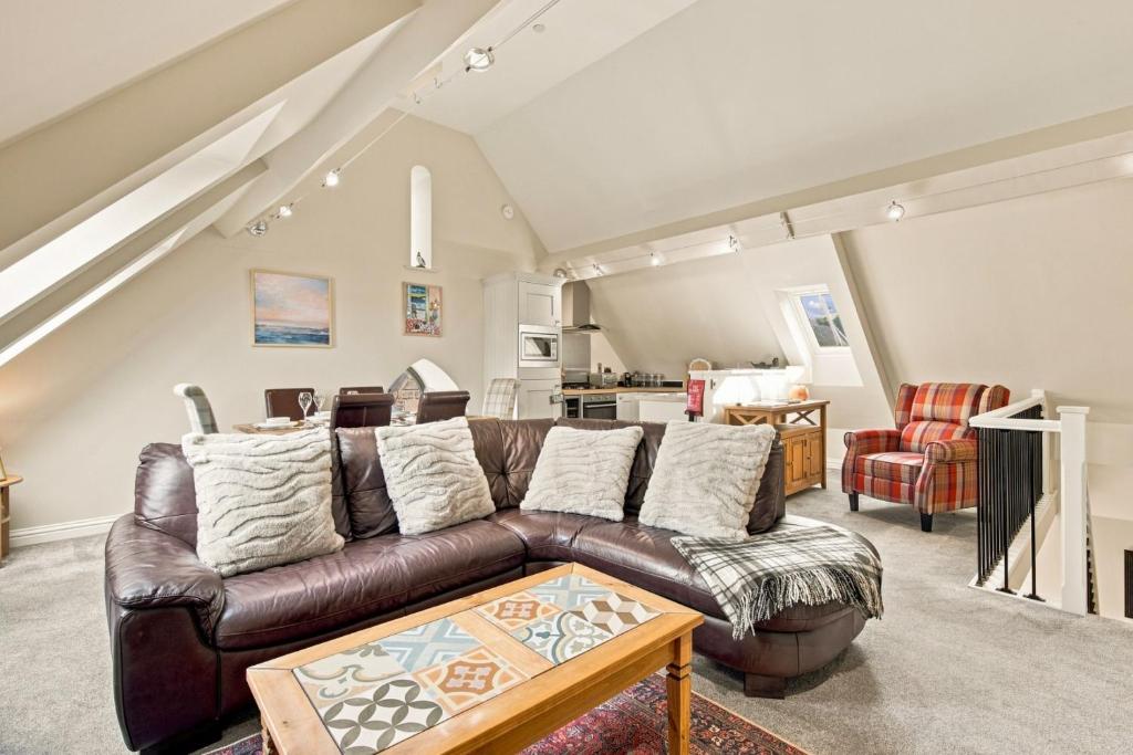 a living room with a brown leather couch at 5 Old Templars - North East Escapes in Spittal
