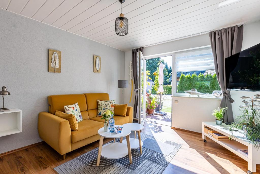 a living room with a yellow couch and a table at Sonnenblumenhaus 01 in Prerow