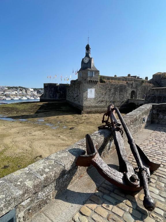 a bike chained to a wall next to the ocean at Gite Gavotte in Concarneau