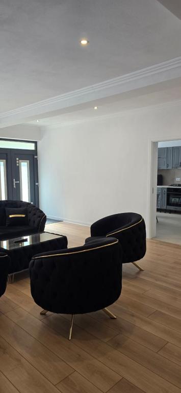 a living room with black chairs and a table at Casa Chișcău - Valea Urșilor in Chişcău