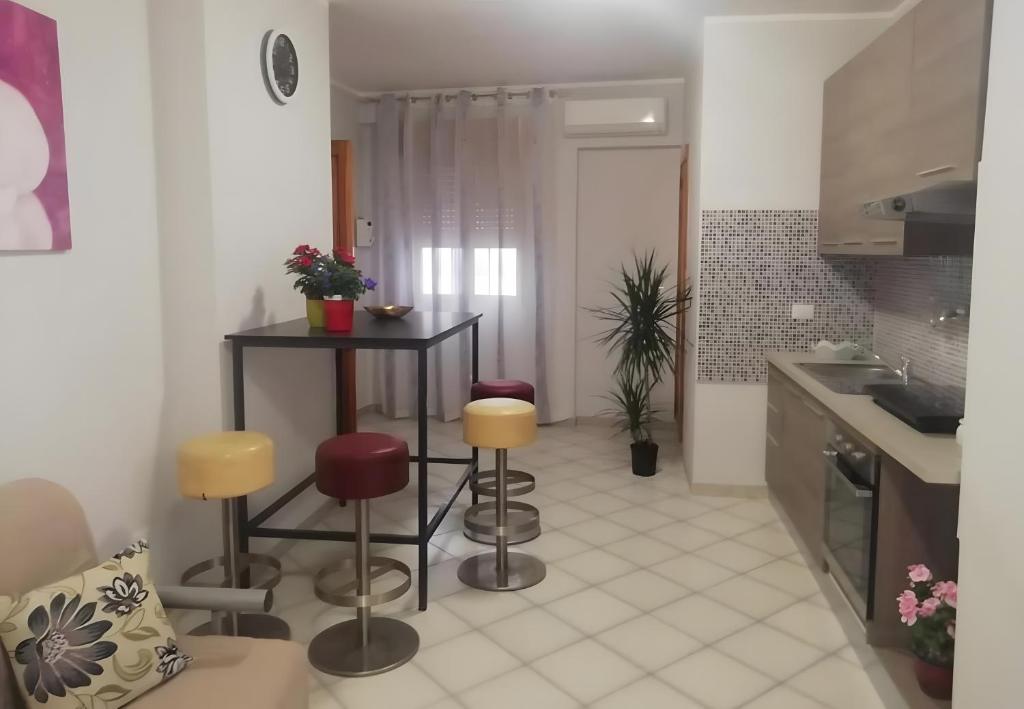 a kitchen with a table and stools in a room at Stella Del Sud in Squinzano