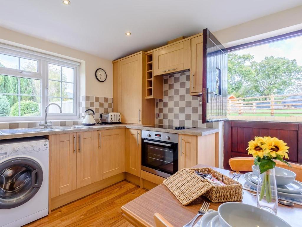 a kitchen with a table with a vase of flowers at 1 Bed in Conwy oc-79357 in Llangelynin