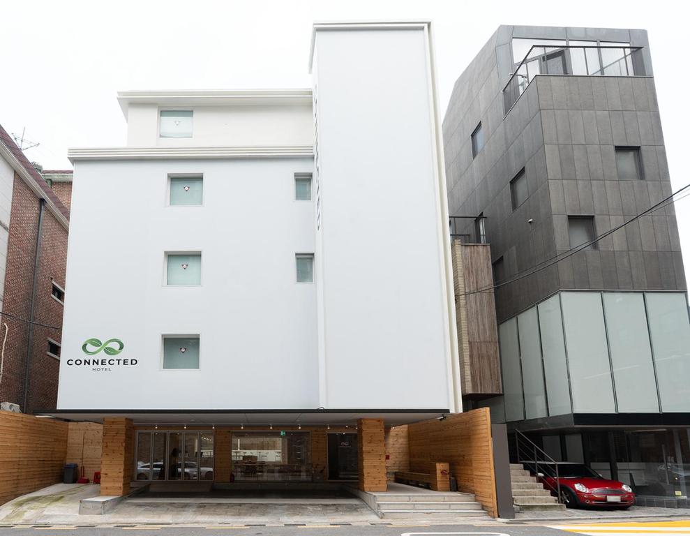 a white building with a car parked in front of it at Connected Hotel Nonhyeon in Seoul