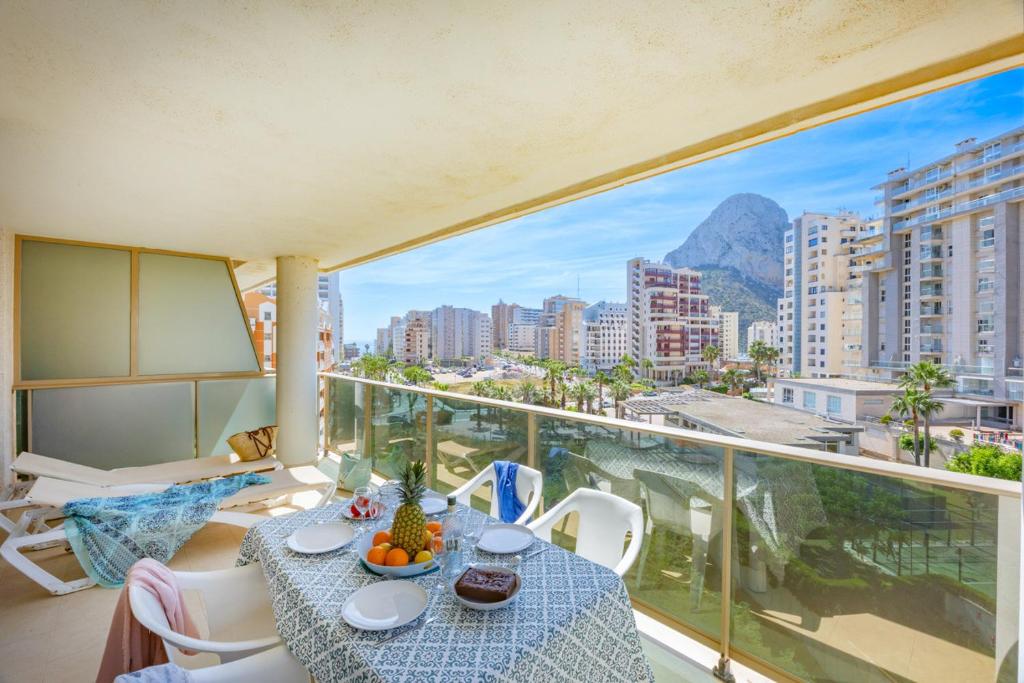 a balcony with a table and a view of a city at Apartamento Larimar - PlusHolidays in Ifach