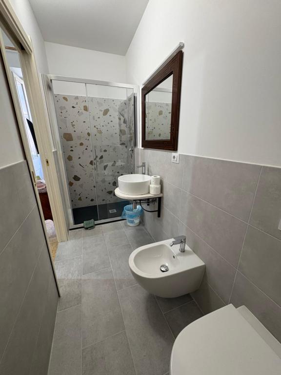 a bathroom with a sink and a toilet and a mirror at Atelier Peretti in Alghero