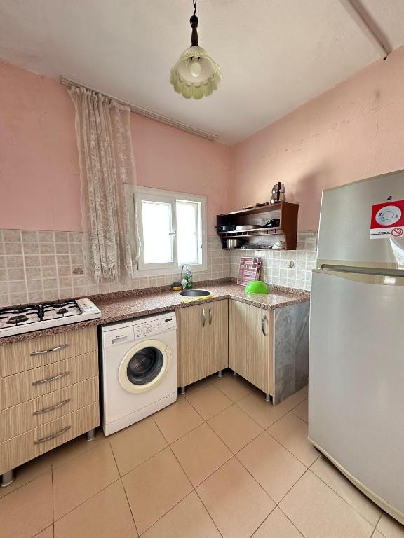 a kitchen with a refrigerator and a washing machine at Yalçın Pansiyon in Silifke