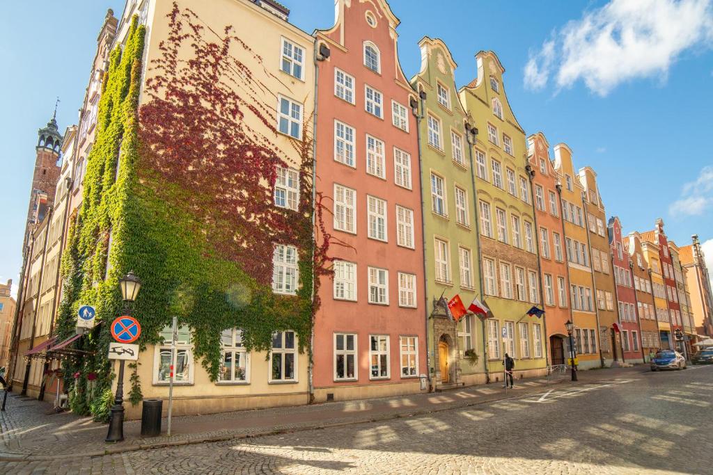a building with ivy growing on the side of it at Hotel Artus - Old Town in Gdańsk