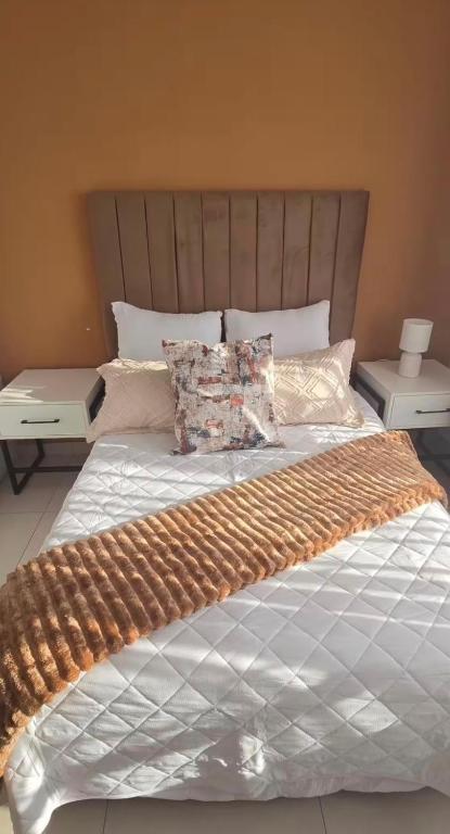 ein Schlafzimmer mit einem großen Bett mit hölzernem Kopfteil in der Unterkunft Asantha in Kalka