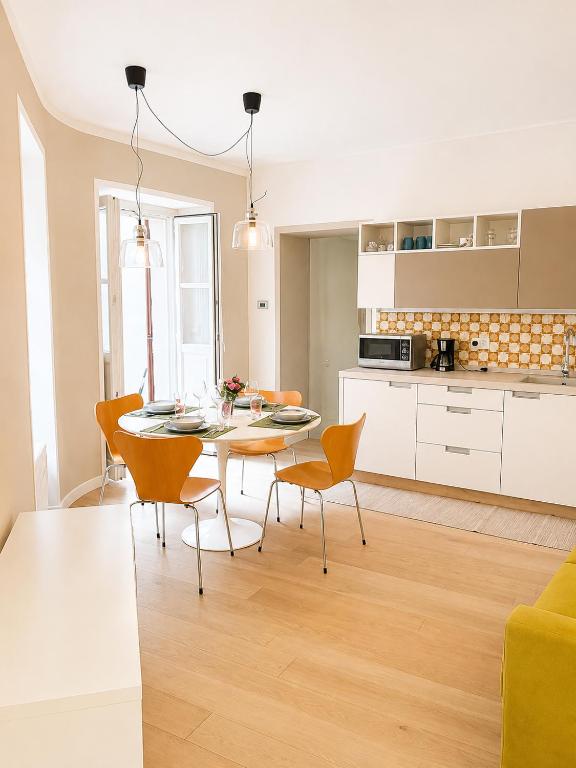 a kitchen and dining room with a table and chairs at The Secret Lakeside in Gravedona