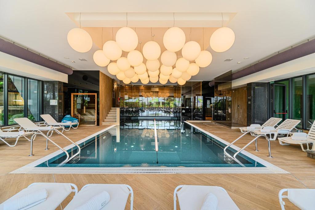 a hotel lobby with a pool and chairs and lights at Complex Hotelier COTA O MIE in Sinaia