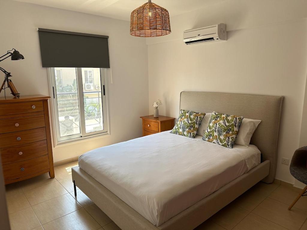 a bedroom with a bed and a dresser and a window at Horizon Court in Kiti