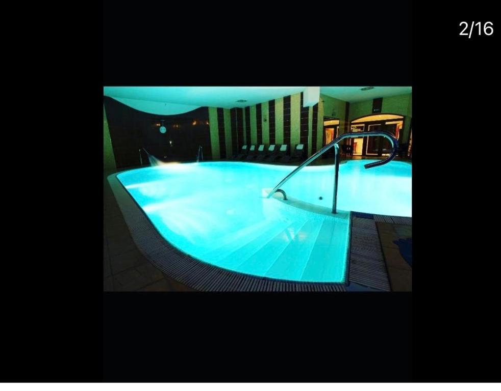 a large blue swimming pool in a building at Wellness hotel Velky Meder in Veľký Meder