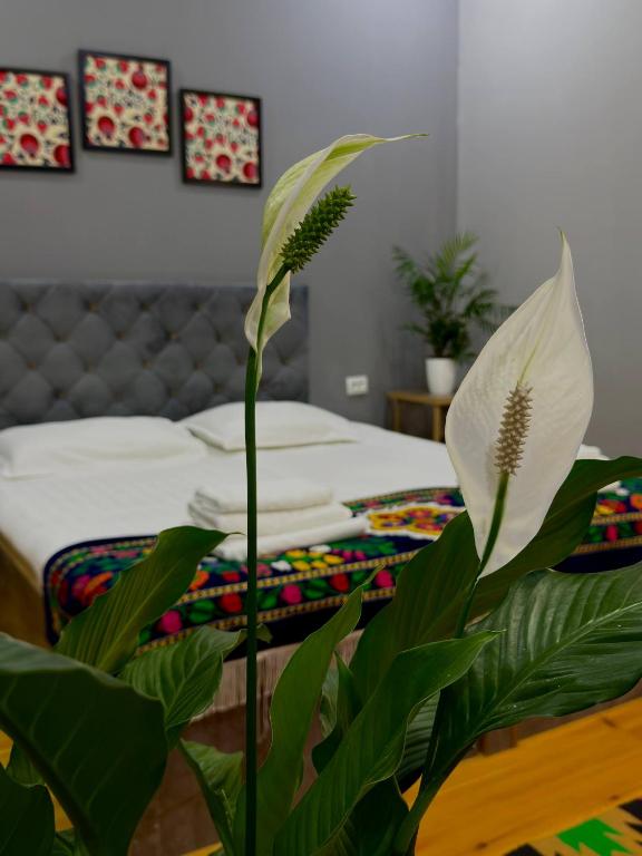 a bedroom with a bed and a white flower at The Art Hotel by Art Hostel in Yakkasaray