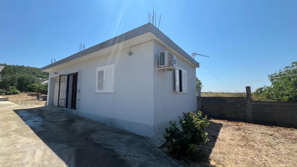 a white building with a door and a fence at Vacation Home Hoxha in Rrotull