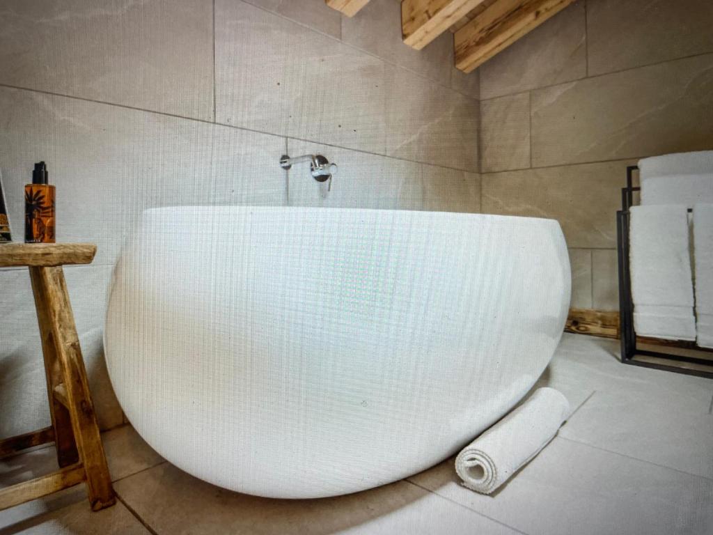 a white tub in a bathroom with a roll of toilet paper at Crystal Lodge St Moritz in St. Moritz