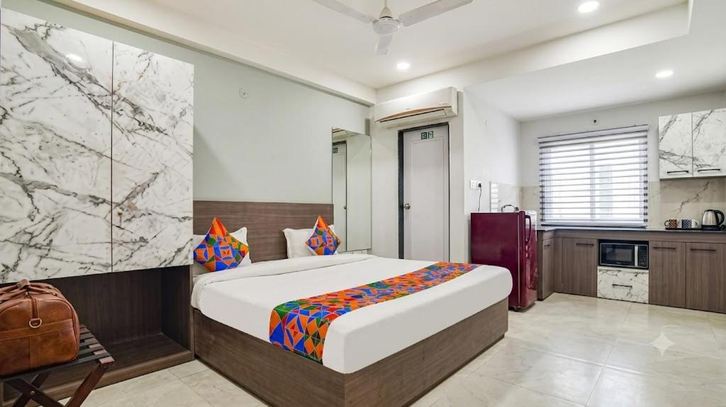 a bedroom with a large bed and a kitchen at homly hotel in Indore