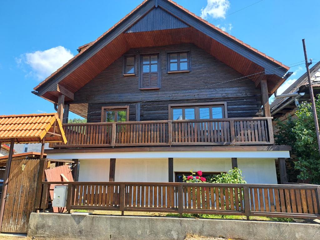 a large wooden house with a balcony at Drevenica Šumiac in Šumiac
