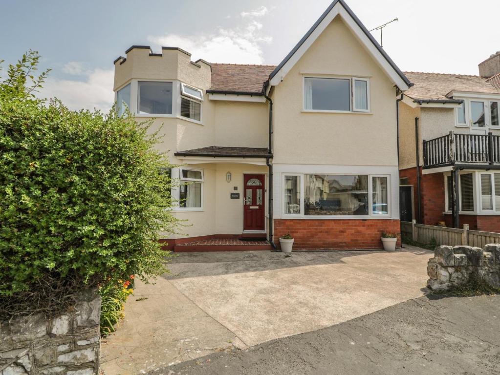 a large house with a red door at Roma in Rhos-on-Sea