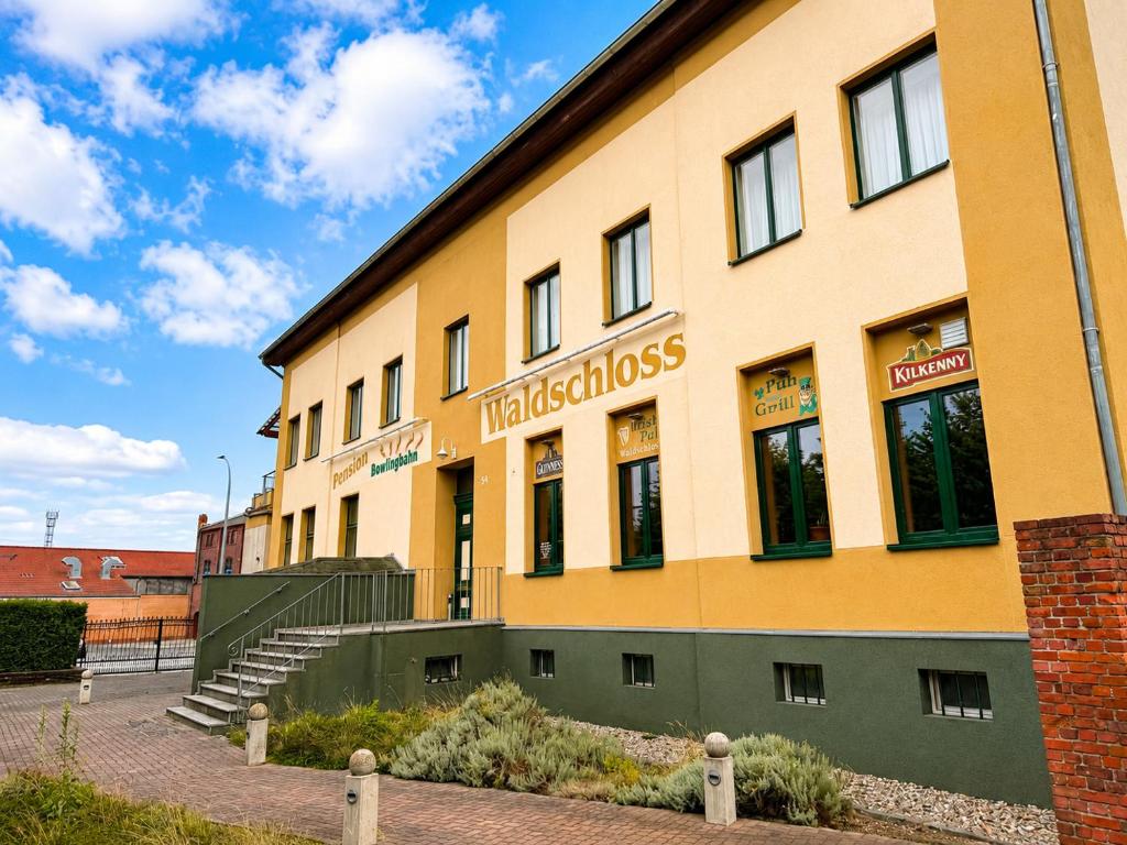 a building with a sign on the side of it at Waldschloss Rathenow in Rathenow