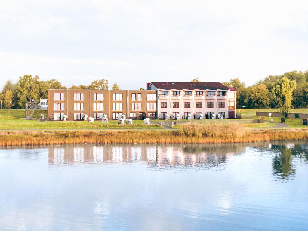 a large building next to a large body of water at BE BIO Hotel be natural - direkt am Wasser in Tönning