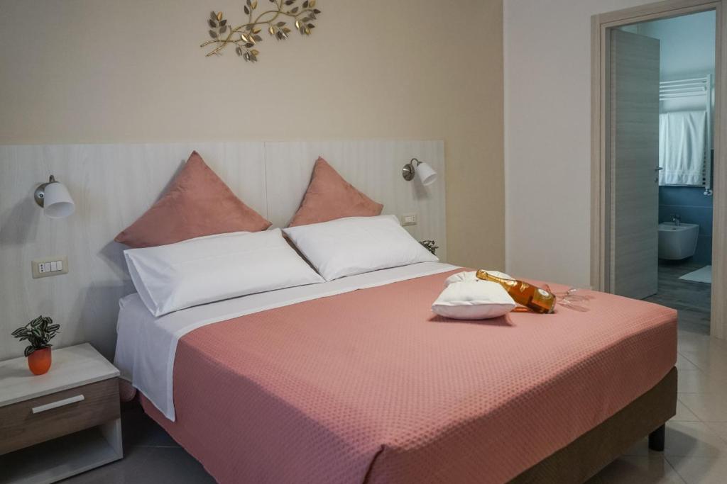 a bedroom with a large bed with pink sheets and pillows at Nonna Carmela Holiday House in San Lazzaro Agerola