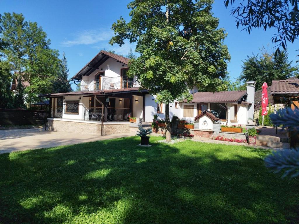 a house with a green lawn in front of it at Casa Carolianne in Bran