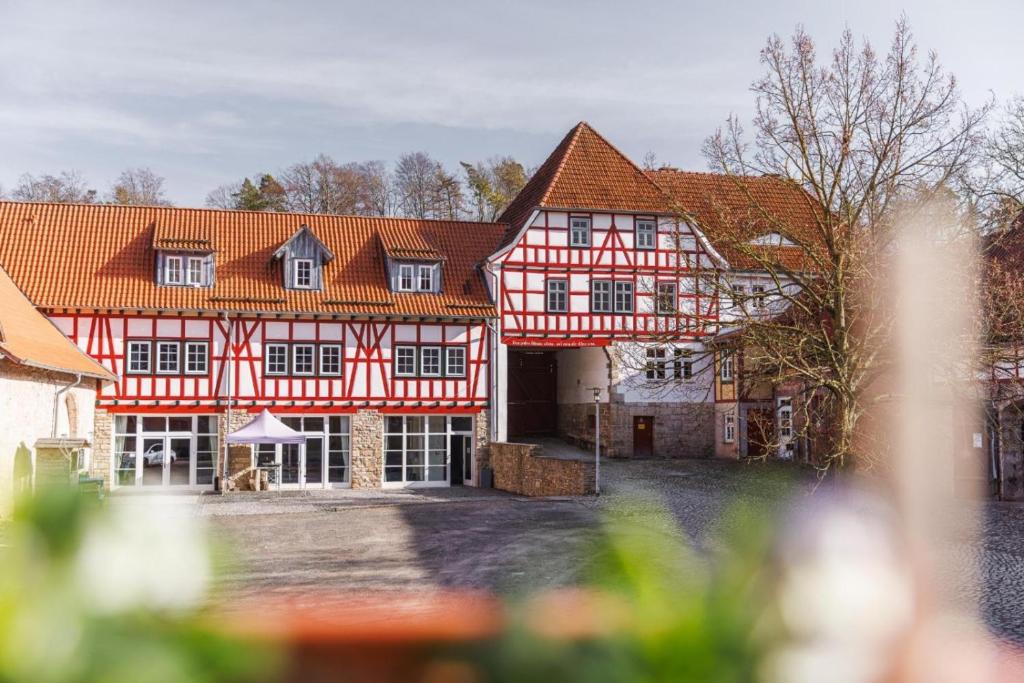a large building with red and white timbered at Gut Beinrode in Kallmerode