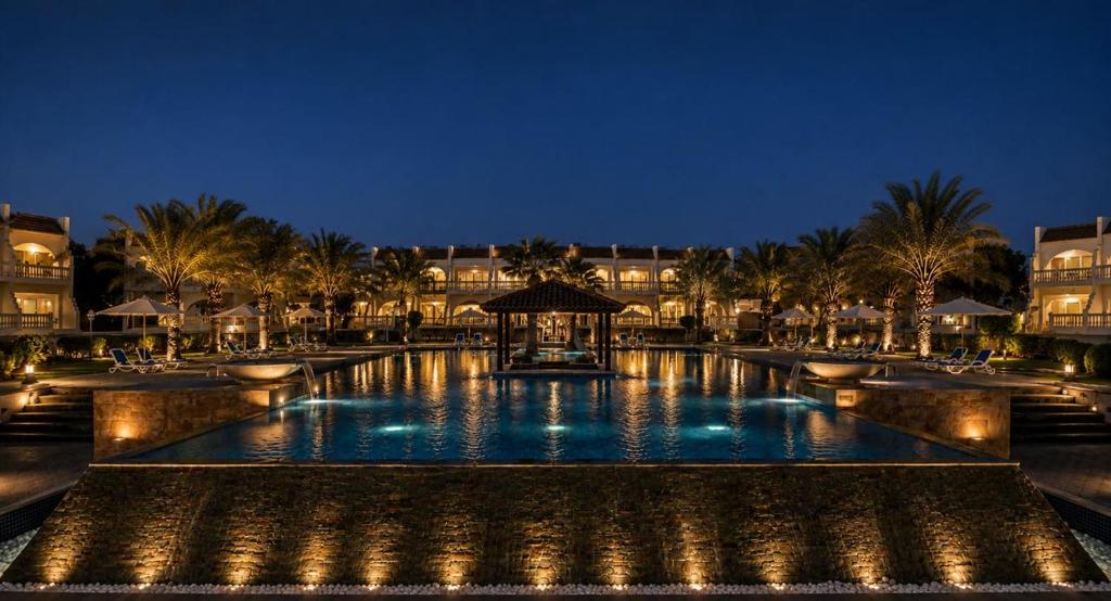 a large swimming pool with a gazebo at night at Barracuda Resort in Umm Al Quwain