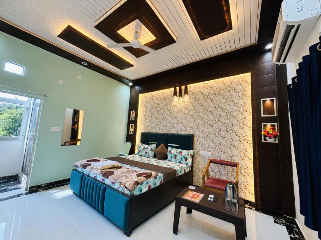 a bedroom with a bed and a table in it at Hotel Vishnu Priya Ayodhya in Ayodhya