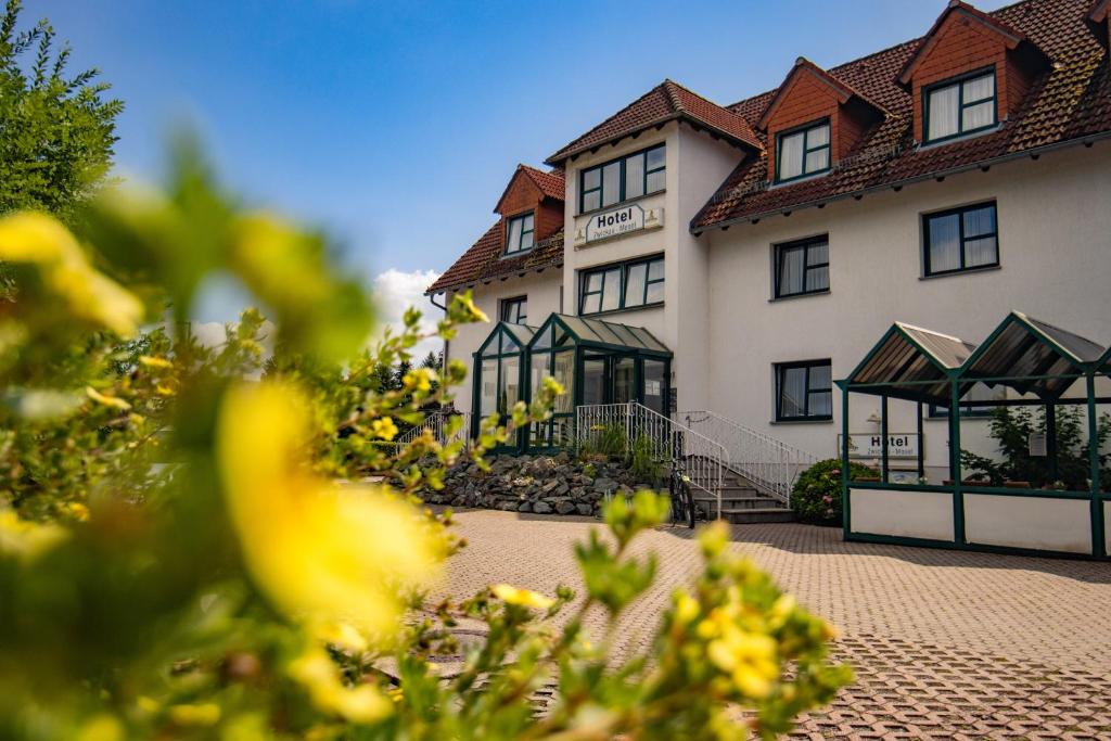 a large white building with black windows at Hotel garni Zwickau-Mosel in Mülsen