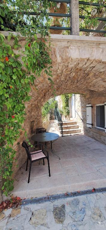Eine Bank steht neben einer Steinmauer mit einem Tisch. in der Unterkunft Authentique-CAVE Les Assions in Les Assions