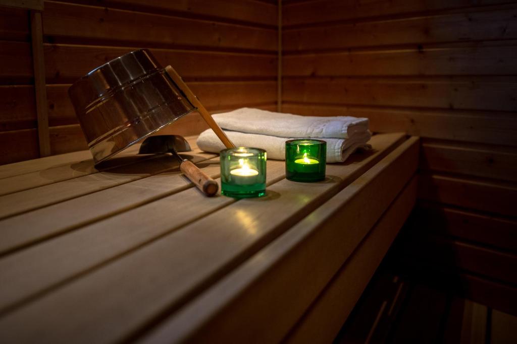 two green candles sitting on a table in a sauna at Tanhuvaaran urheiluopisto & Sport Resort in Savonlinna