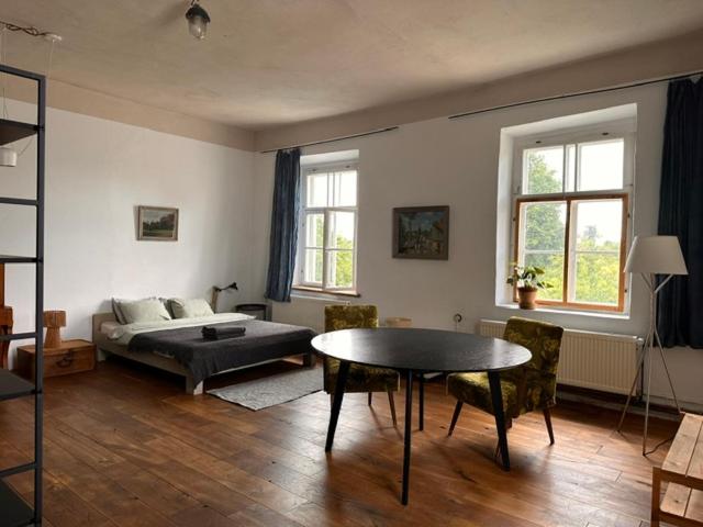 a bedroom with a bed and a table and chairs at Room 0 in The White House Residence in Kuldīga