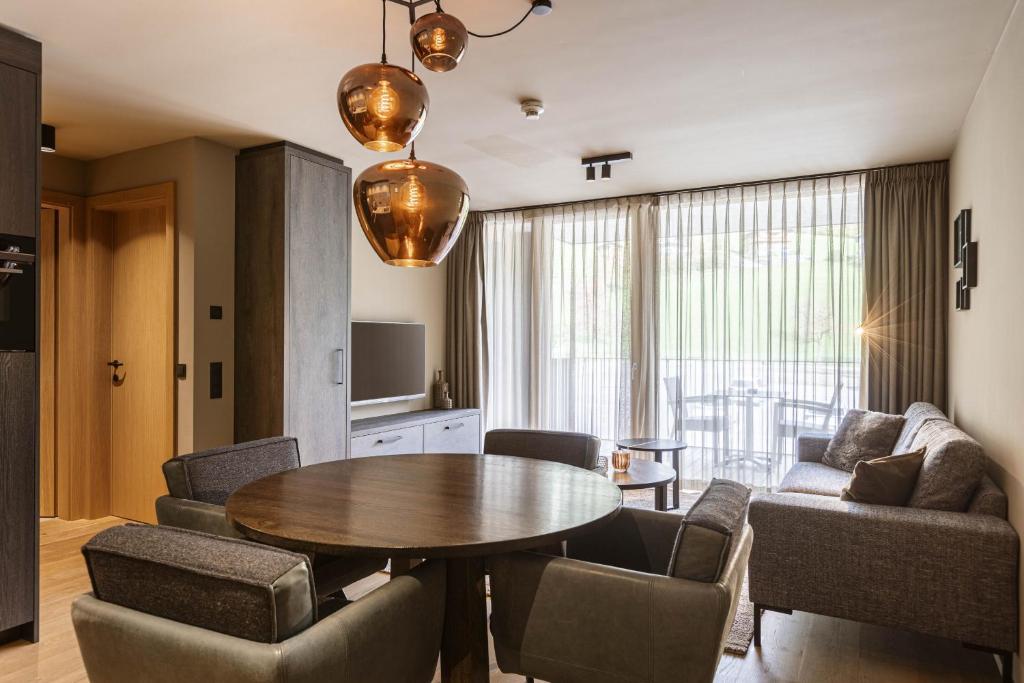 a living room with a table and chairs and a couch at Montafon Suites Schruns by ALPS RESORTS in Schruns