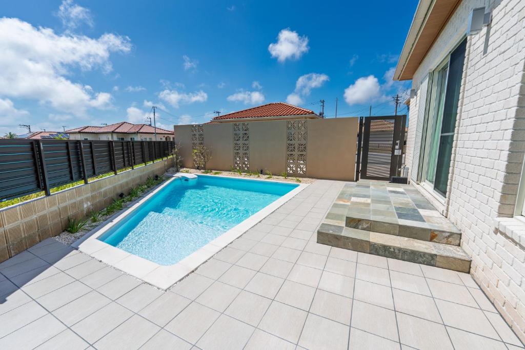 a swimming pool in the backyard of a house at Villa Arco Miyakojima in Miyako-jima