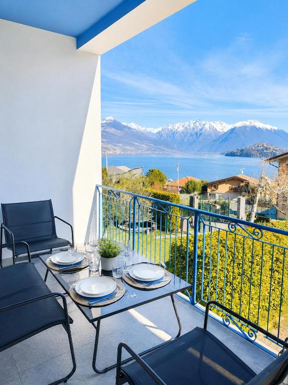 a balcony with a table and chairs and a view of the mountains at The Blue Sky Apartment with Lake view in Pianello Del Lario