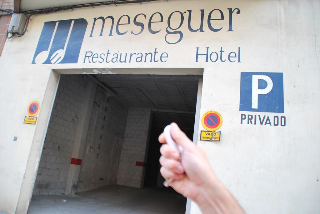 a person giving a thumbs up in front of a hospital at Aparthotel Meseguer in Alcañiz