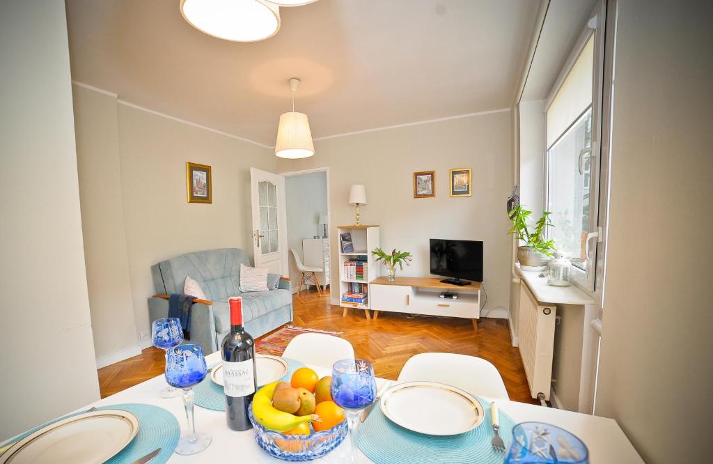 a living room with a table with a bottle of wine at Merida Apartament in Sopot